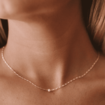 The Carmel Necklace in silver features a link chain with a fixed pearl