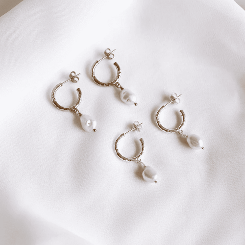 Harper Earrings feature a hoop style studs with a pearl drop charm