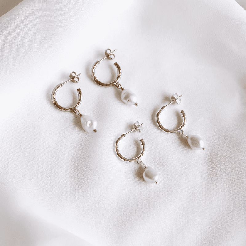 Harper Earrings feature a hoop style studs with a pearl drop charm